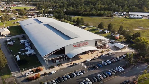 An aerial view of QSEC, a large building with carpark out the front and shed in the background.